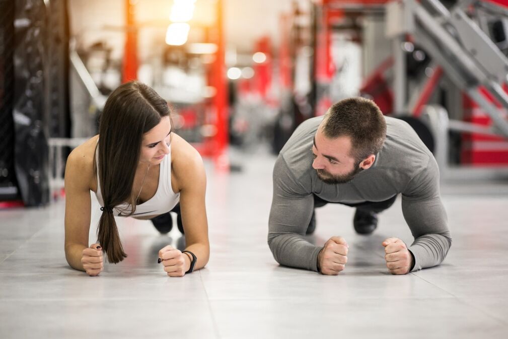 Vyras ir moteris atlieka Plank pratimą, skirtą visoms raumenų grupėms